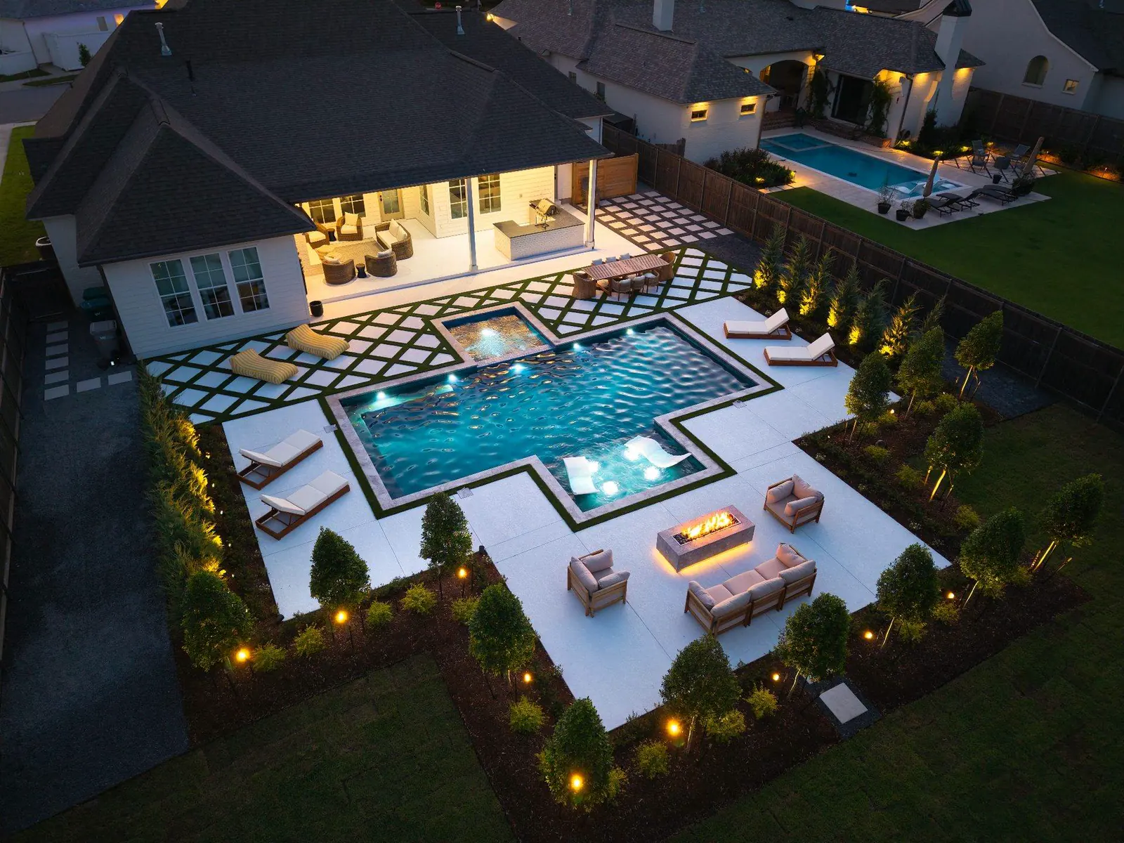 Custom geometric pool with spa, turf diamonds, and lit patio in Breaux Bridge
