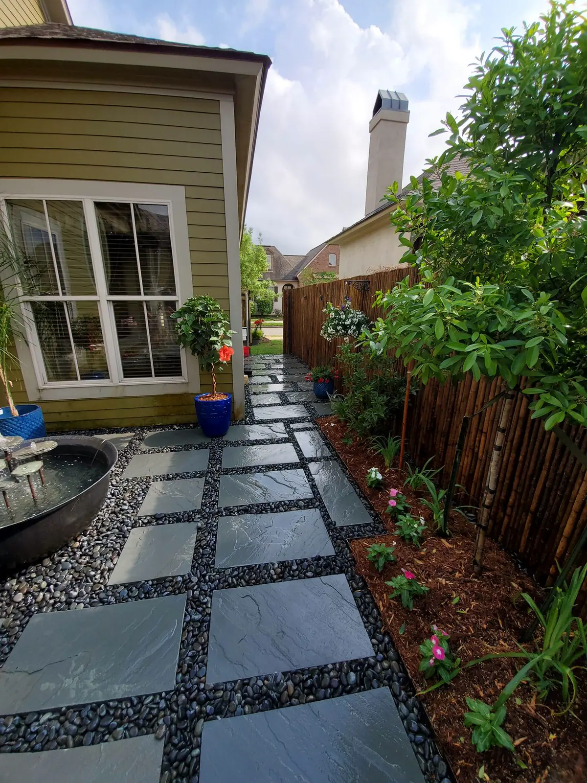 Backyard stepping-stone path through new plantings toward a fence